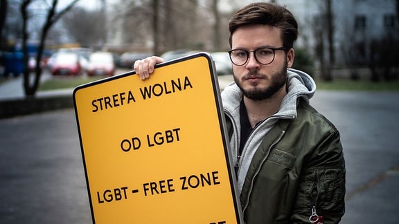 Aktivist Bartek Staszewski mit einem Schild mit der Aufschrift "LGBT-freie Zone"