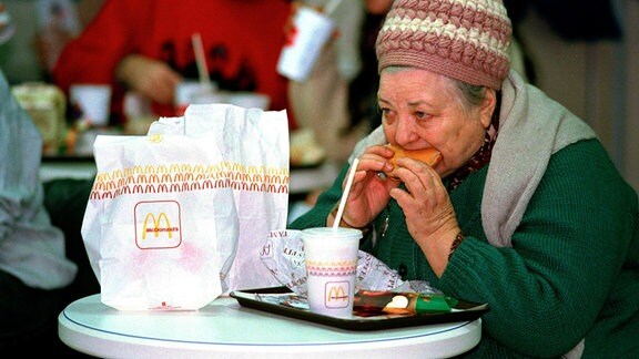 Seniorin isst 1990 einen Hamburger von McDonald's in Moskau