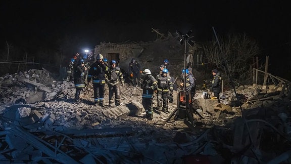 Auf diesem vom ukrainischen Notdienst zur Verfügung gestellten Foto untersuchen Feuerwehrleute ein Wohnhaus das bei einem russischen Raketenangriff getroffen wurde.