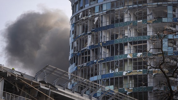 Rauch steigt hinter einem Gebäude auf, das bei einem russischen Raketenangriff in Kiew beschädigt wurde.