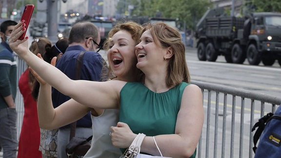 Zwei Frauen machen ein Selfie auf der Übung zur Militärparade in Moskau. 