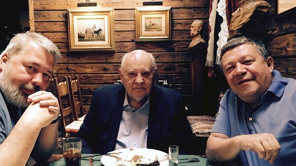 Privatarchiv Ruslan Grinberg mit Michail Gorbatschow und Dimitri Muratow an einem Tisch sitzend.