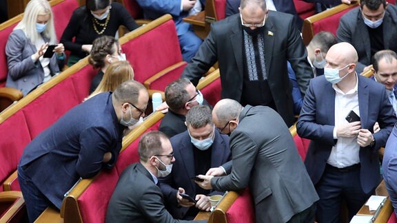 Parlamentarier schauen auf ihre Handys