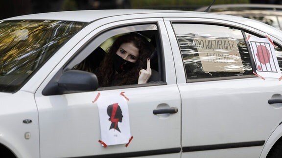 Frau im Auto zeigt den Mittelfinger