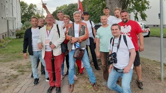 Janusz Zagórski mit Menschgruppe un  polnischer Flagge auf Straße