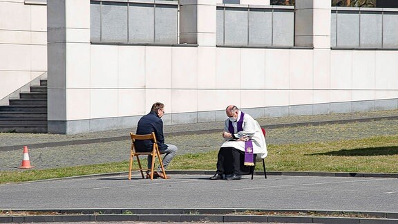 Mann trifft einen Priester auf einem Parkplatz
