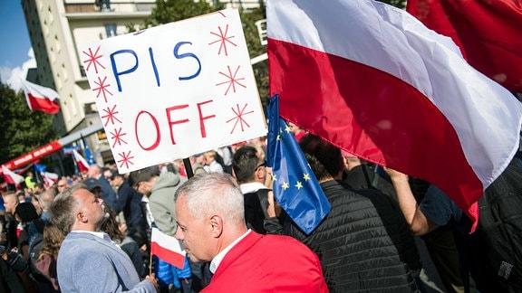 Während des Millionen-Herzen-Marsches in Warschau halten Menschen Plakate gegen Recht und Gerechtigkeit hoch und schwenken polnische Flaggen.