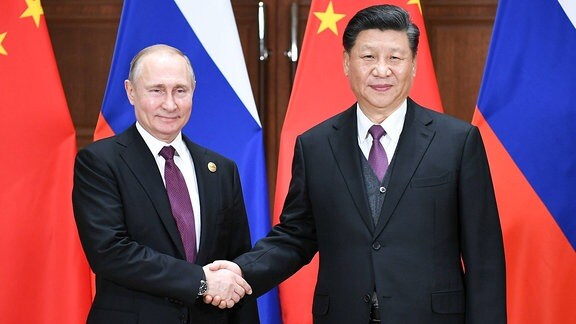 Putin und Jingping reichen sich die Hand.