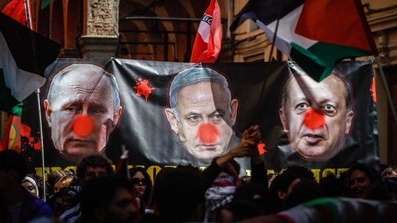 Demonstranten halten während der Demonstration anlässlich des 81. Jahrestages des Befreiungstages ein Transparent gegen die Politiker Wladimir Putin, Benjamin Netanjahu und Erdogan