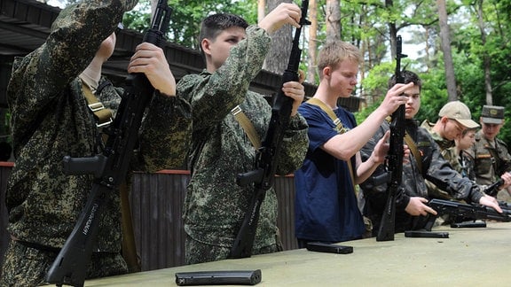 Wehrpflichtige nehmen an einer Lektion über das Zerlegen und Zusammensetzen eines Kalaschnikow-Sturmgewehrs während eines Ausbildungslagers im Avangard-Ausbildungszentrum im Dorf Georgievsky, Region Tambov, Russland, teil.