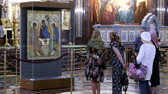 Gläubige stehen vor der Dreifaltigkeitsikone von Andrei Rublev aus dem 15. Jahrhundert, die in der Christ-Erlöser-Kathedrale ausgestellt ist.