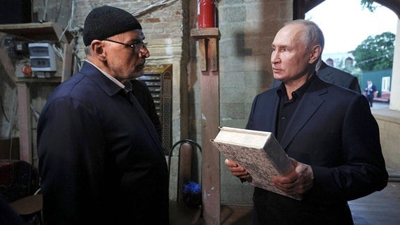 Wladimir Putin hält ein Buch