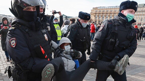 Polizisten tragen Demonstranten weg.