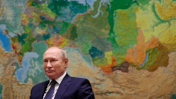 Der russische Präsident Wladimir Putin vor einer Landkarte