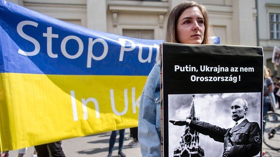 Eine Frau hält ein Plakat bei einer Solidartitaetsdemonstration für die Ukraine.