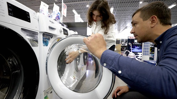 Kunden im Elektromarkt bei den Waschmaschinen.