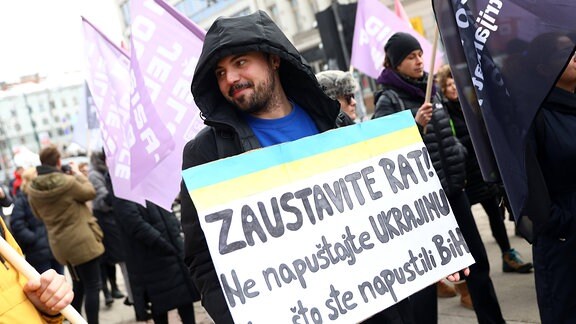 Ein Mann hält ein Transparent während einer Demonstration zum Internationalen Frauentag in Sarajewo, Bosnien und Herzegowina