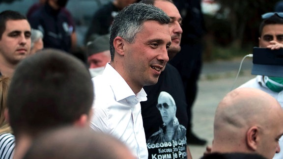 Oppositionsführer Bosko Obradovic mit seinen Anhängern von der Partei Dveri und Männern mit Wladimir Putin T-Shirt im Hintergrund.