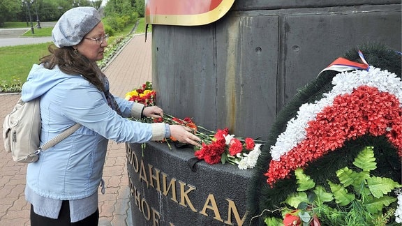 MURMANSK, RUSSIA - JULY 3, 2019: People bring flowers to a Navy memorial at the Church of the Saviour on Waters to commemorate 14 Russian Navy officers who died in a fire on a research deep-sea submersible in Russia s northern territorial waters on 1 July 2019.