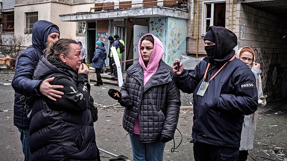 Menschen stehen vor einem Haus in Kiew