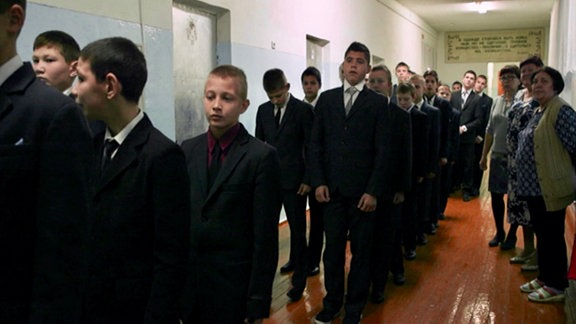 Schüler in russischem Umerziehungsanstalt laufen im Gleichschritt über den Gang