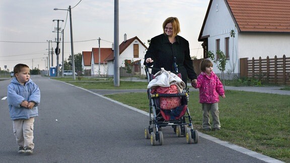 Eine Mutter unterwegs mit zwei kleinen Kindern