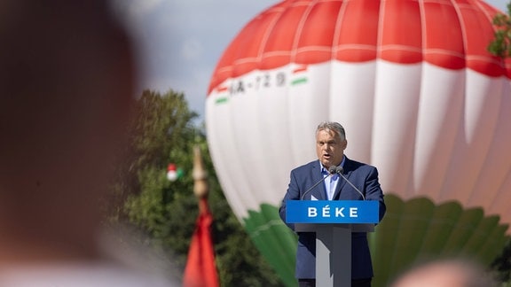 Viktor Orban am Rednerpult, im Hintergrund ein Ballon in den ungarischen Nationalfarben.