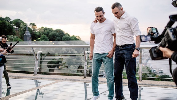 Vitali Klitschko und sein Bruder Wladimir stehen auf einer Brücke.