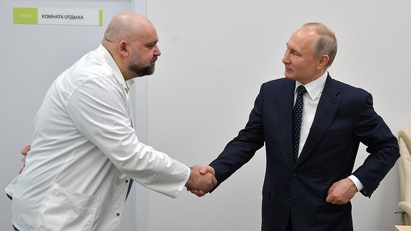 Wladimir Putin schüttelt einem Mann die Hand