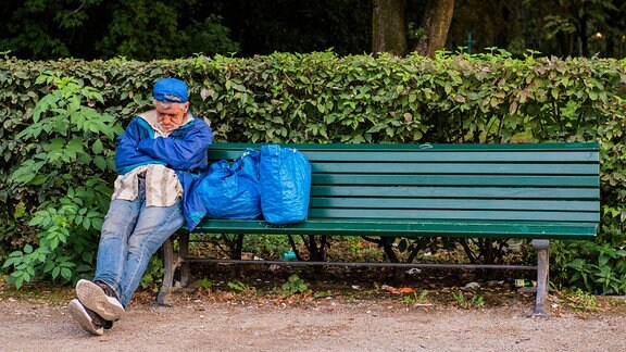 Obdachloser auf einer Parkbank