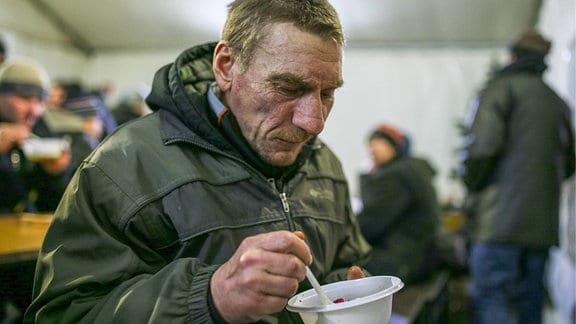Mann mit isst 2017 in einem Obdachlosenheim