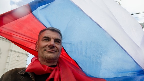Mann trägt russische Fahne