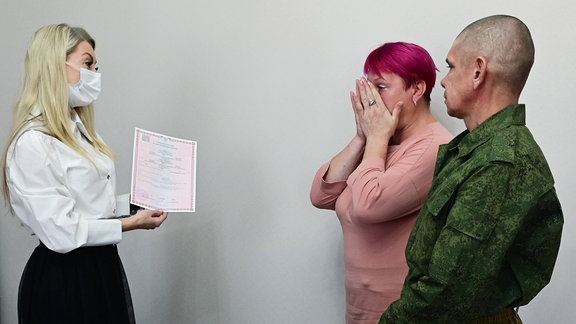 Ein frisch verheiratetes Paar erhält eine Heiratsurkunde bei der Registrierung im Standesamt der Stadt Tschita, Russland.