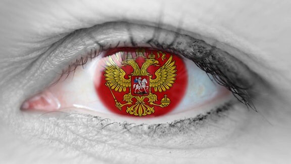 Symbolbild zur Krise in der Ukraine und der Politik Russland s: Auge, in dem das Wappen Russland s leuchtet.