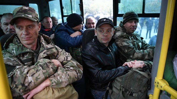 Einberufene Männer sitzen in einem Bus.
