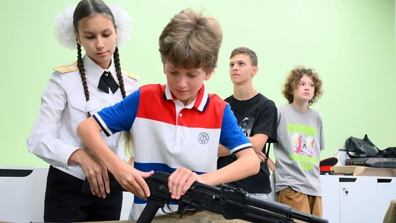 Ein Junge baut beim Tag der offenen Tür einer Schule in Moskau, während eines Rundgangs für Eltern und Kinder, in einem militärischen Grundausbildungskurs eine Sturmgewehrattrappe zusammen.