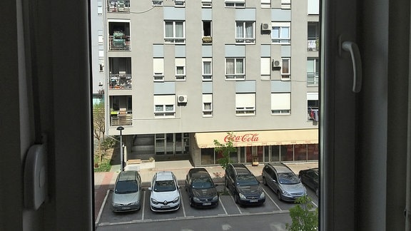 Blick aus Fenster auf graue Hausfassade