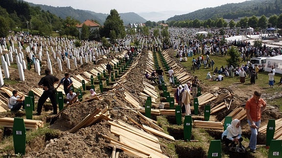 Menschen bereiten Grablöcher für die Überreste der Opfer des Massakers von Srebrenica in Srebrenica, Bosnien-Herzegowina, vor.