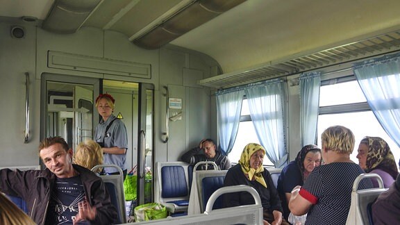 Passagiere sitzen im Abteil eines Zuges