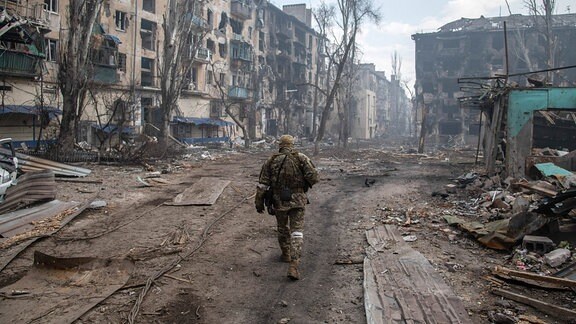 Ein russischer Soldat zwischen zerstörten Häusern