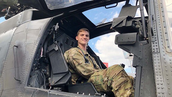 Ein Soldat sitzt in einem Hubschrauber.