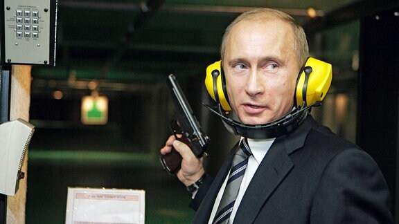Der russische Präsident Wladimir Putin trägt Ohrenschützer und hält eine Pistole bei einem Besuch des neuen Hauptquartiers des Hauptnachrichtendienstes (GRU) des Generalstabs der russischen Streitkräfte.