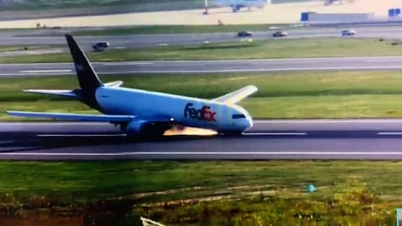 Eine Boeing 763 schrammt über die Landebahn: Weil sich das Vorderrad nicht ausfahren ließ, musste das Flugzeug auf dem Rumpf landen. Es sprühen die Funken.