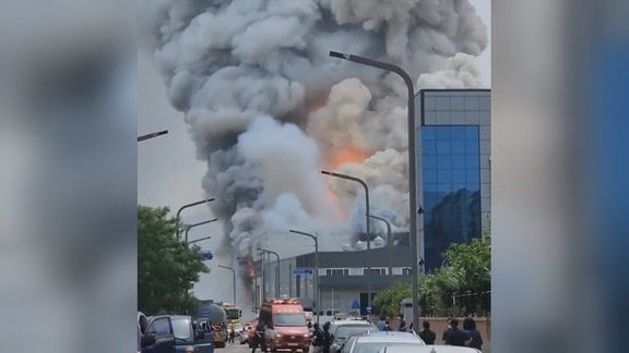Riesige Rauchschwaden steigen über einem Fabrikgebäude auf