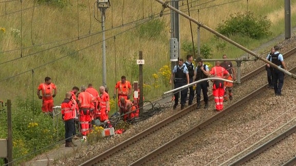 Techniker und Polizisten an einer Bahnanlage in Frankreich