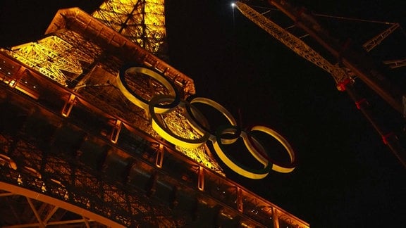 Eiffelturm bei Nacht Blick nach Oben auf die Ringe, die mit einem Kran angebracht werden. 
