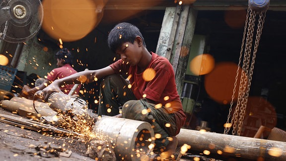 Ein Junge arbeitet auf einer Schiffswerft in Dhaka