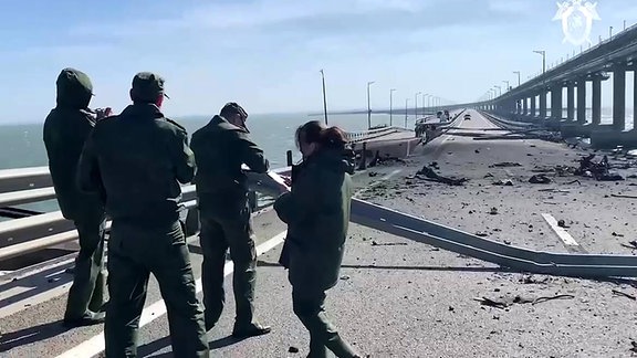 Ermittler am Ort der Explosion eines Lastwagens auf der Krimbrücke, die das russische Festland und die Halbinsel Krim verbindet