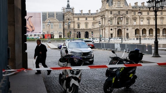 Polizeibeamte stehen vor dem Louvre Wache, der wegen einer Bombendrohung geräumt wurde.
