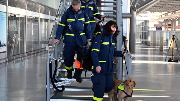 Rettungskräfte des Technischen Hilfswerks (THW) gehen durch den Flughafen Köln/Bonn